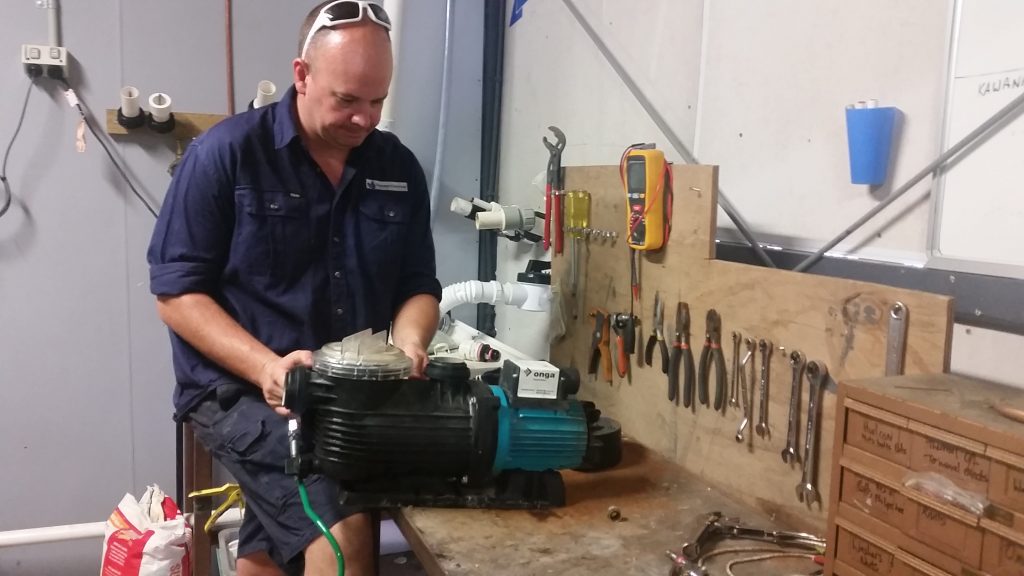Picture of a technician conducting pool pump repairs on our test bench.