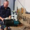 Picture of a technician conducting pool pump repairs on our test bench.